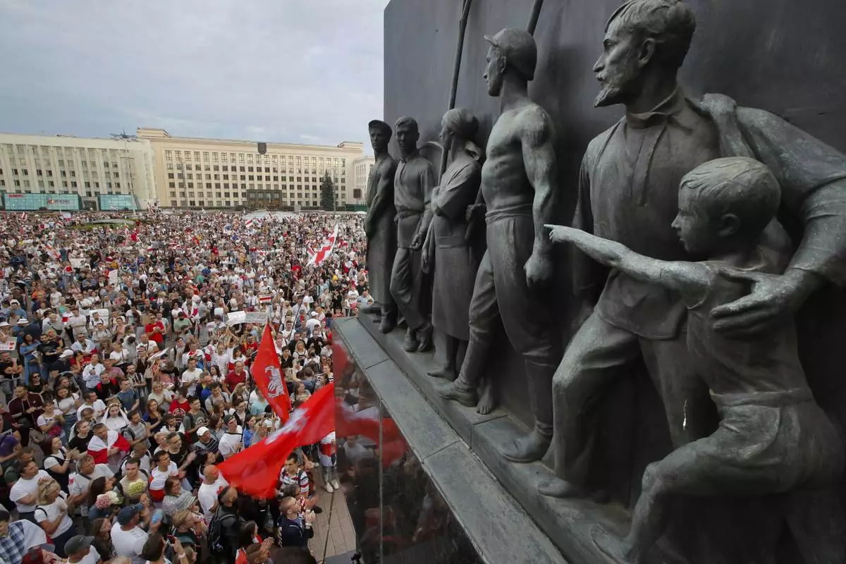 FILE - Belarusian opposition supporters gather for a protest in front of the government building at Independence Square in Minsk, Belarus, with a Soviet-era monument in the foreground, on Aug. 18, 2020. (AP Photo/Dmitri Lovetsky, File)