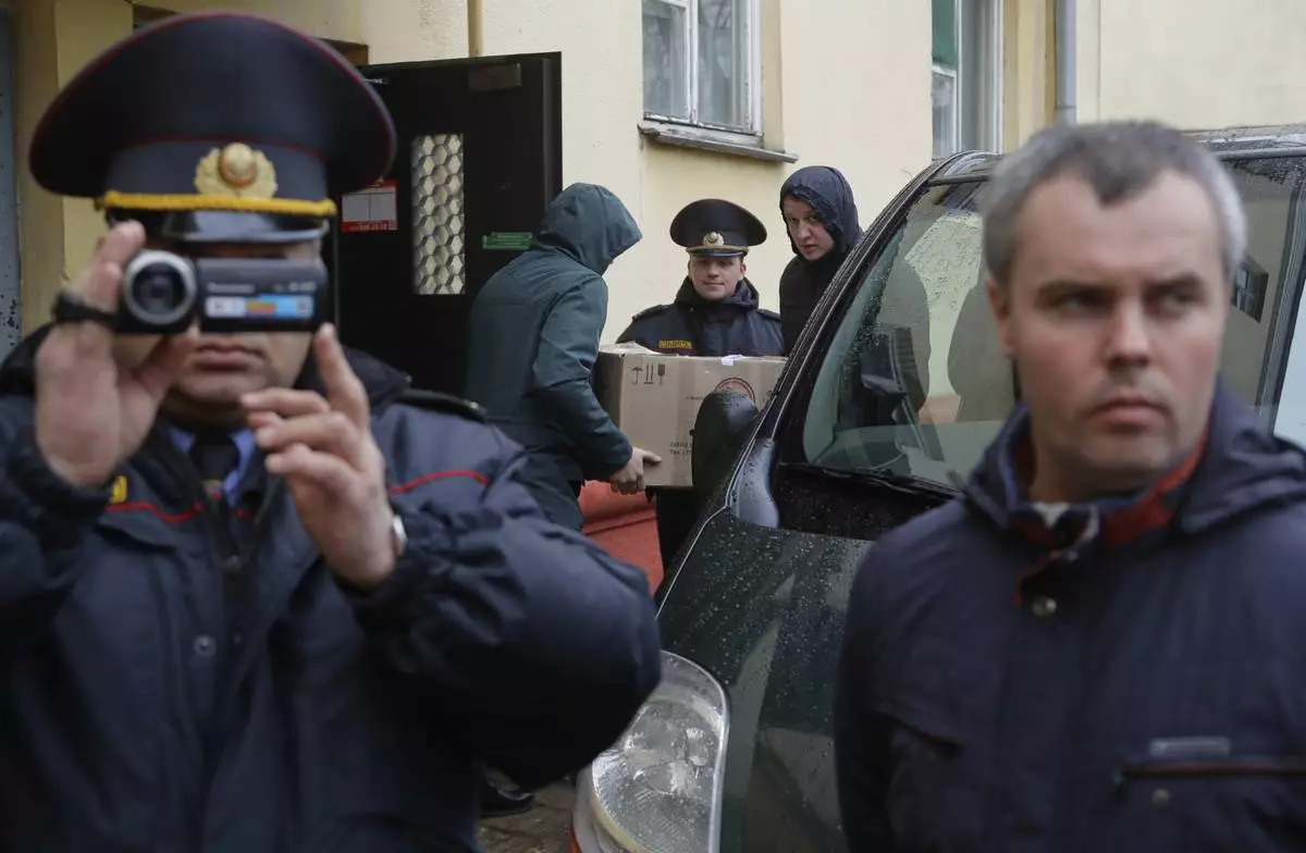 FILE - Belarusian Interior Ministry officer films journalists near the Belsat Channel during a search of the broadcaster’s office in Minsk, Belarus, on March 31, 2017. (AP Photo, File)