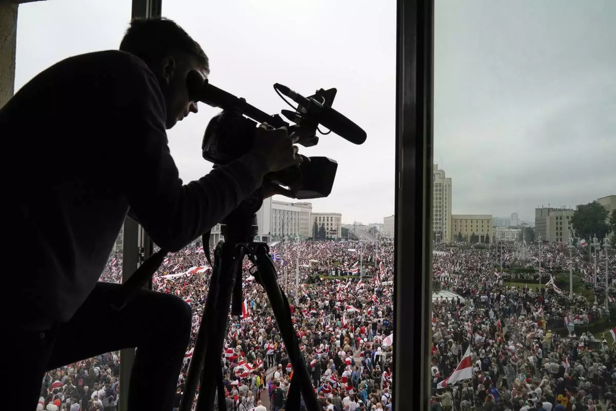 FILE - A cameraman works as Belarusian opposition supporters rally in Independence Square in Minsk, Belarus, on Aug. 23, 2020. (AP Photo/Evgeniy Maloletka, File)