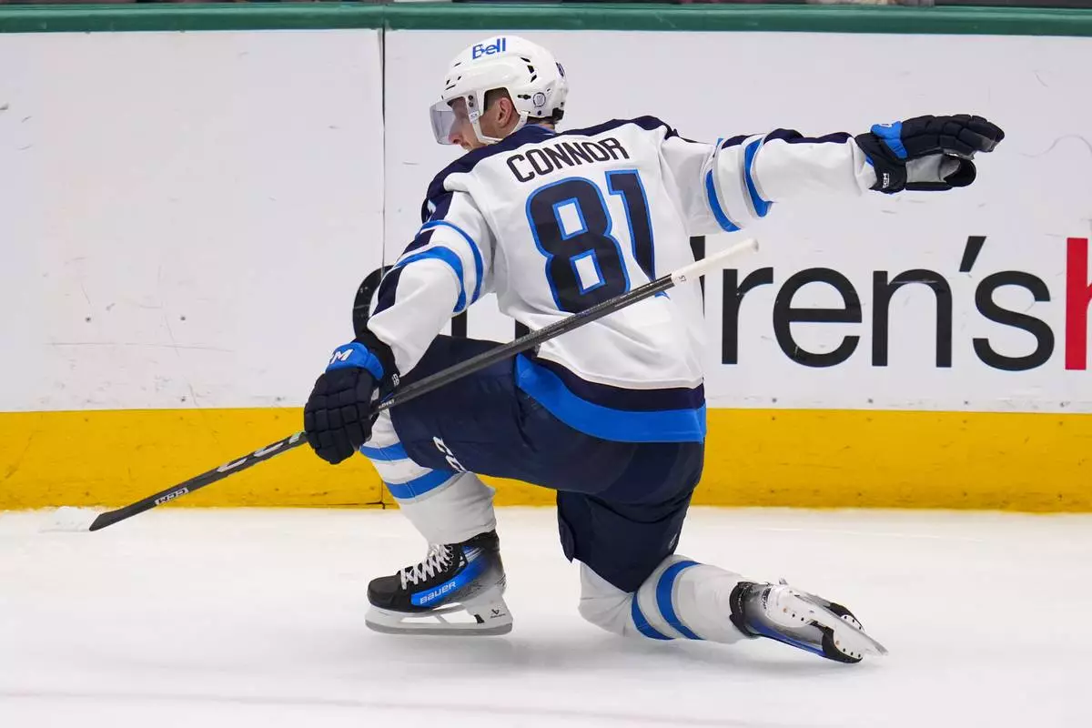 Winnipeg Jets left wing Kyle Connor reacts after scoring a goal against the Dallas Stars during the third period of an NHL hockey game Thursday, April 10, 2025, in Dallas. (AP Photo/Julio Cortez)