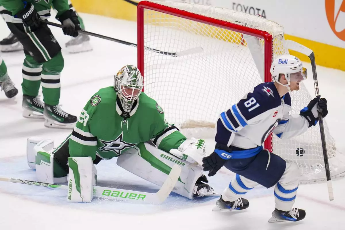 Winnipeg Jets left wing Kyle Connor (81) reacts after scoring a goal on Dallas Stars goaltender Jake Oettinger (29) during the third period of an NHL hockey game Thursday, April 10, 2025, in Dallas. (AP Photo/Julio Cortez)