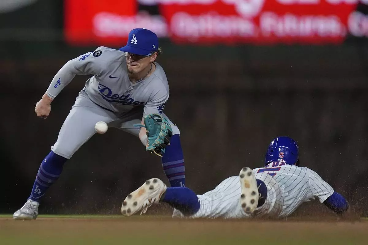 Los Angeles Dodgers first base Kiké Hernández (8), left, can't catch Chicago Cubs' Jon Berti (5) as he steals second base during the eighth inning of a baseball game Tuesday, April 22, 2025, in Chicago. (AP Photo/Erin Hooley)