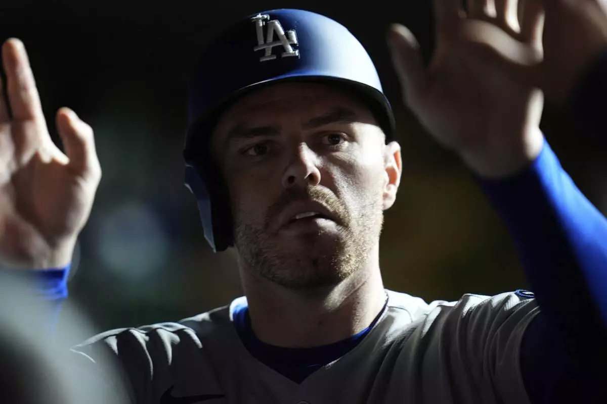 Los Angeles Dodgers' Freddie Freeman (5) celebrates after scoring on a double from Will Smith during the seventh inning of a baseball game against the Chicago Cubs, Tuesday, April 22, 2025, in Chicago. (AP Photo/Erin Hooley)