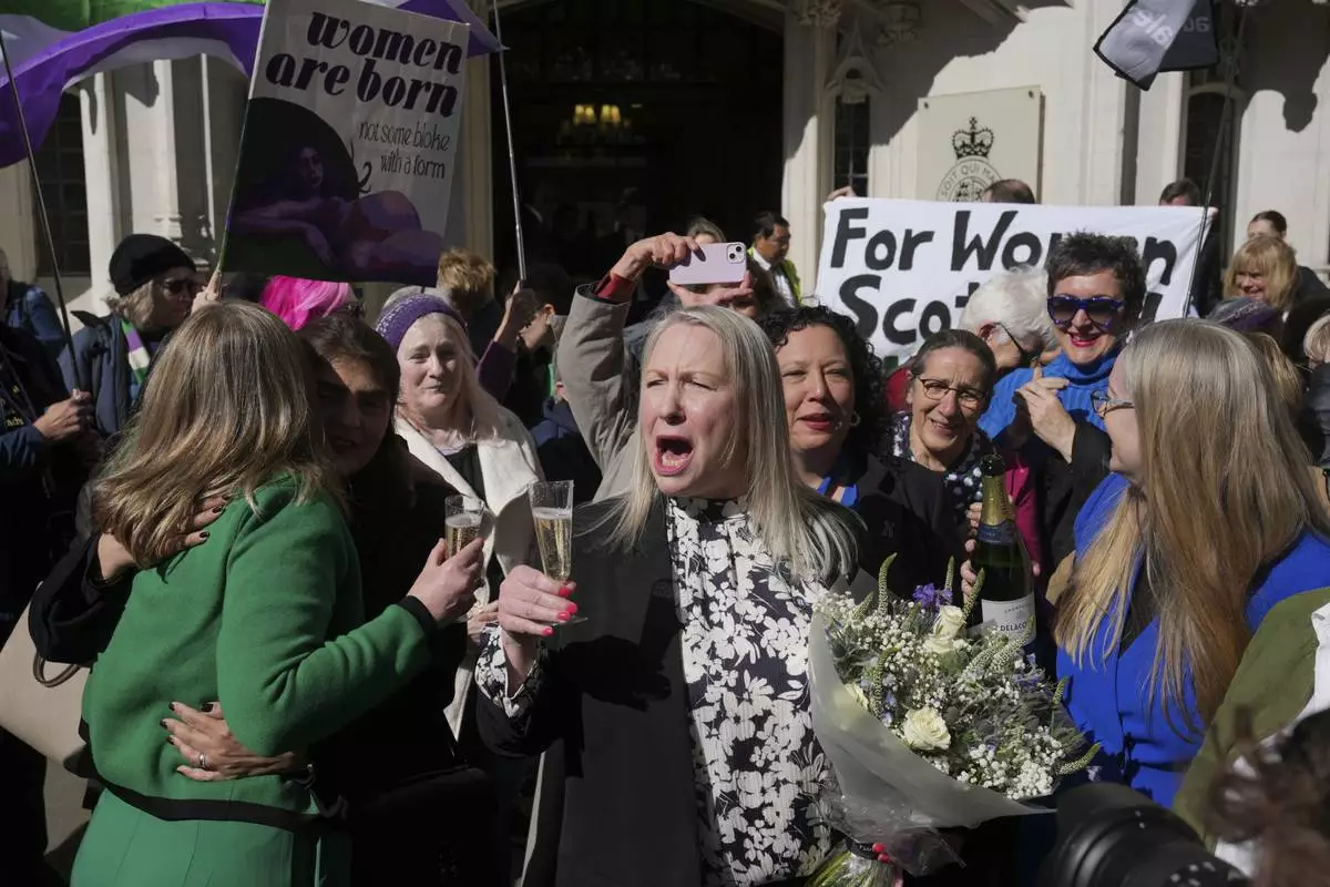 Marion Calder, center, and Susan Smith, left, from For Women Scotland, celebrate outside after the U.K. Supreme Court ruled that a woman is someone born biologically female, excluding transgender people from the legal definition in a long-running dispute between the feminist group and the Scottish government, in London Wednesday, April 16, 2025. (AP Photo/Kin Cheung)