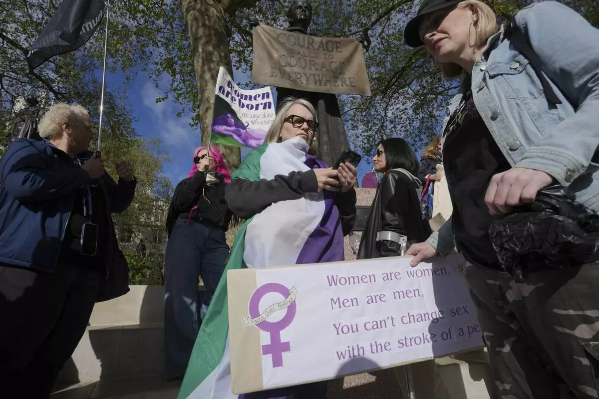 Women's rights activists hold placards outside the Supreme Court to challenge gender recognition laws, in London, Wednesday, April 16, 2025. (AP Photo/Kin Cheung)
