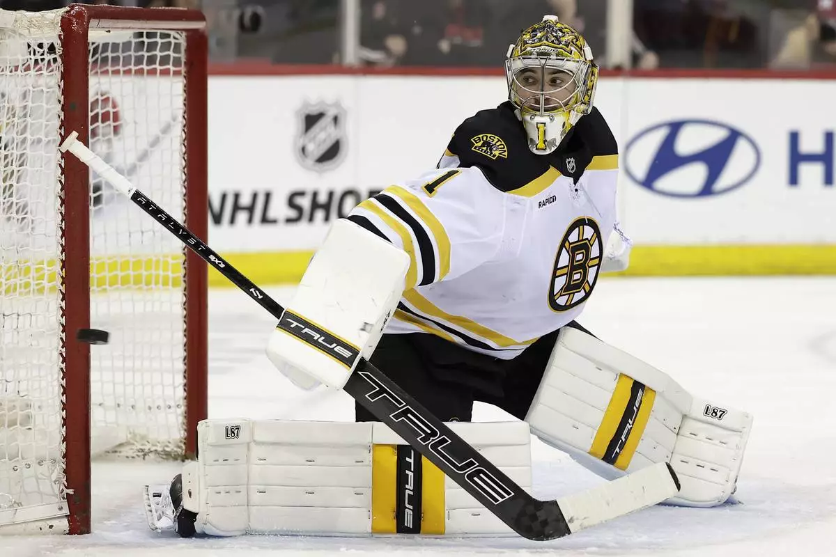 Boston Bruins goaltender Jeremy Swayman watches a shot go wide of the net in the second period of an NHL hockey game against the New Jersey Devils, Tuesday, April 8, 2025, in Newark, N.J. (AP Photo/Adam Hunger)