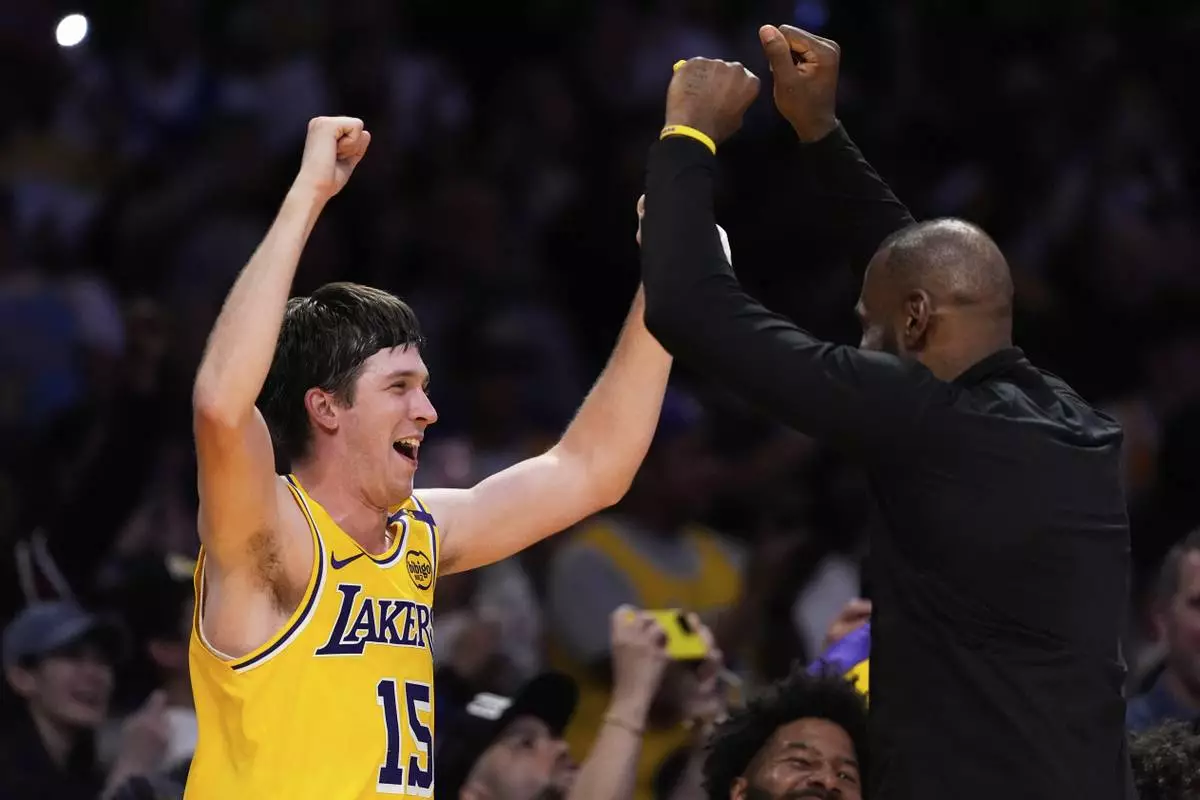 Los Angeles Lakers guard Austin Reaves, left, and forward LeBron James celebrate at the bench during the second half of an NBA basketball game against the Houston Rockets Friday, April 11, 2025, in Los Angeles. (AP Photo/Mark J. Terrill)