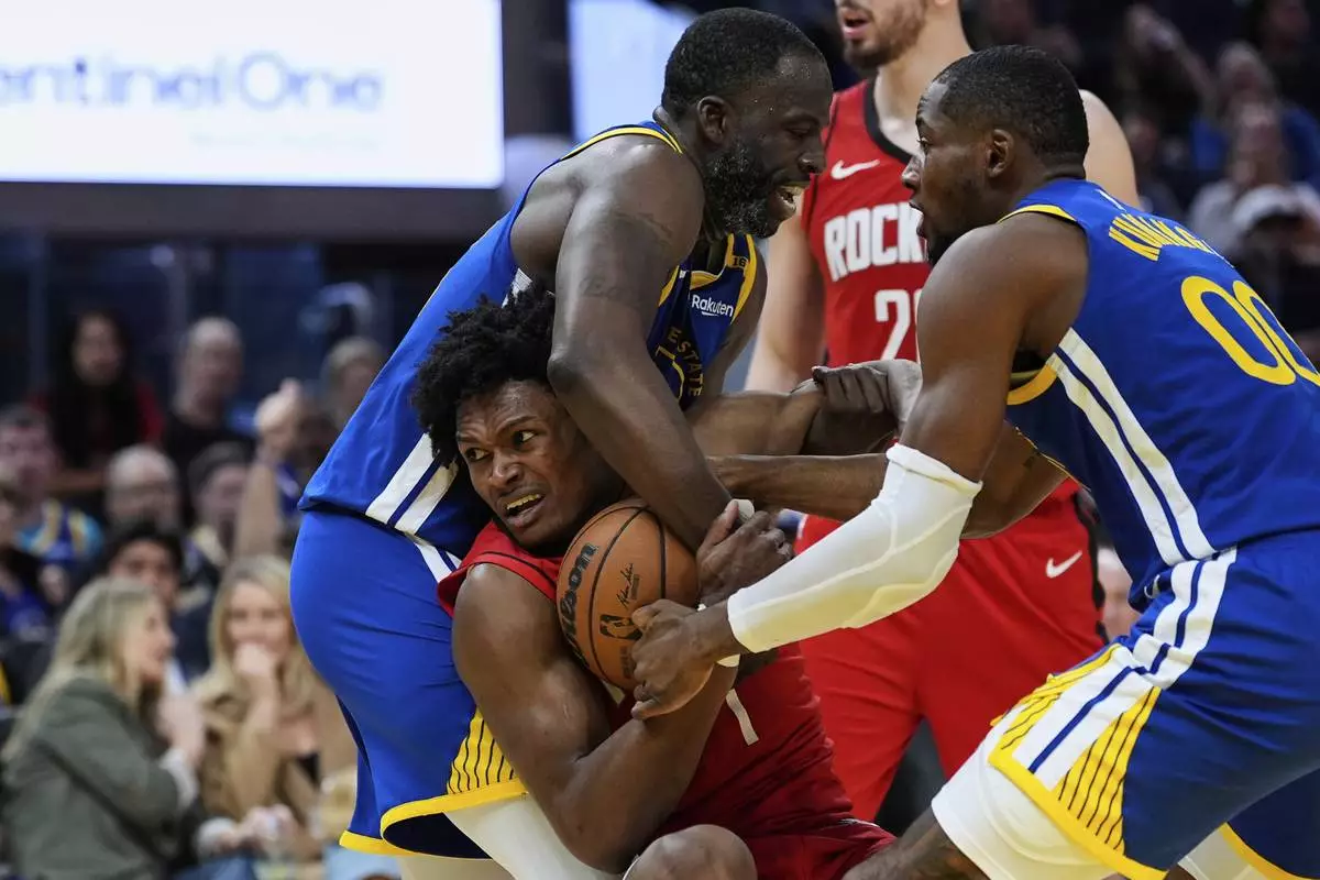 Houston Rockets forward Amen Thompson (1) and Golden State Warriors forward Draymond Green , left, compete for possession of the ball during the second half of an NBA basketball game Sunday, April 6, 2025, in San Francisco. (AP Photo/Godofredo A. Vásquez)