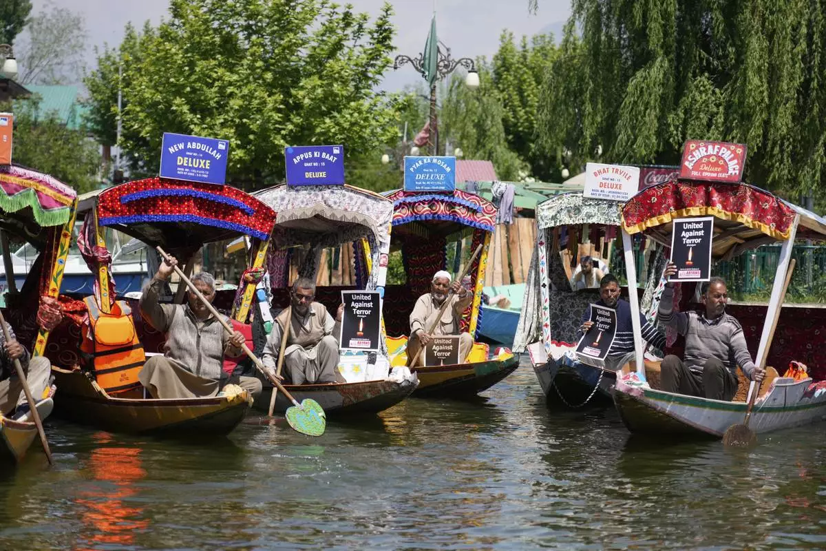 Kashmiri boatmen hold placards as they condemn the tourists killing at Dal Lake in Srinagar, Indian controlled Kashmir, Thursday, April. 24, 2025. (AP Photo/Mukhtar Khan)