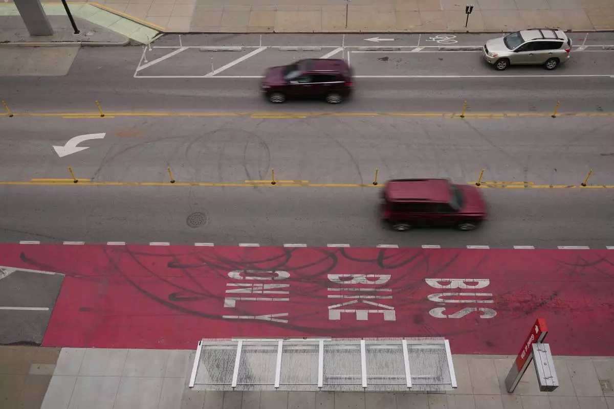 Cars drive on Grand Boulevard in Kansas City, Mo., where the city implemented a "road diet" reducing the street from four lanes to two in an effort to reduce speeding and accidents, Thursday, April 17, 2025. (AP Photo/Charlie Riedel)
