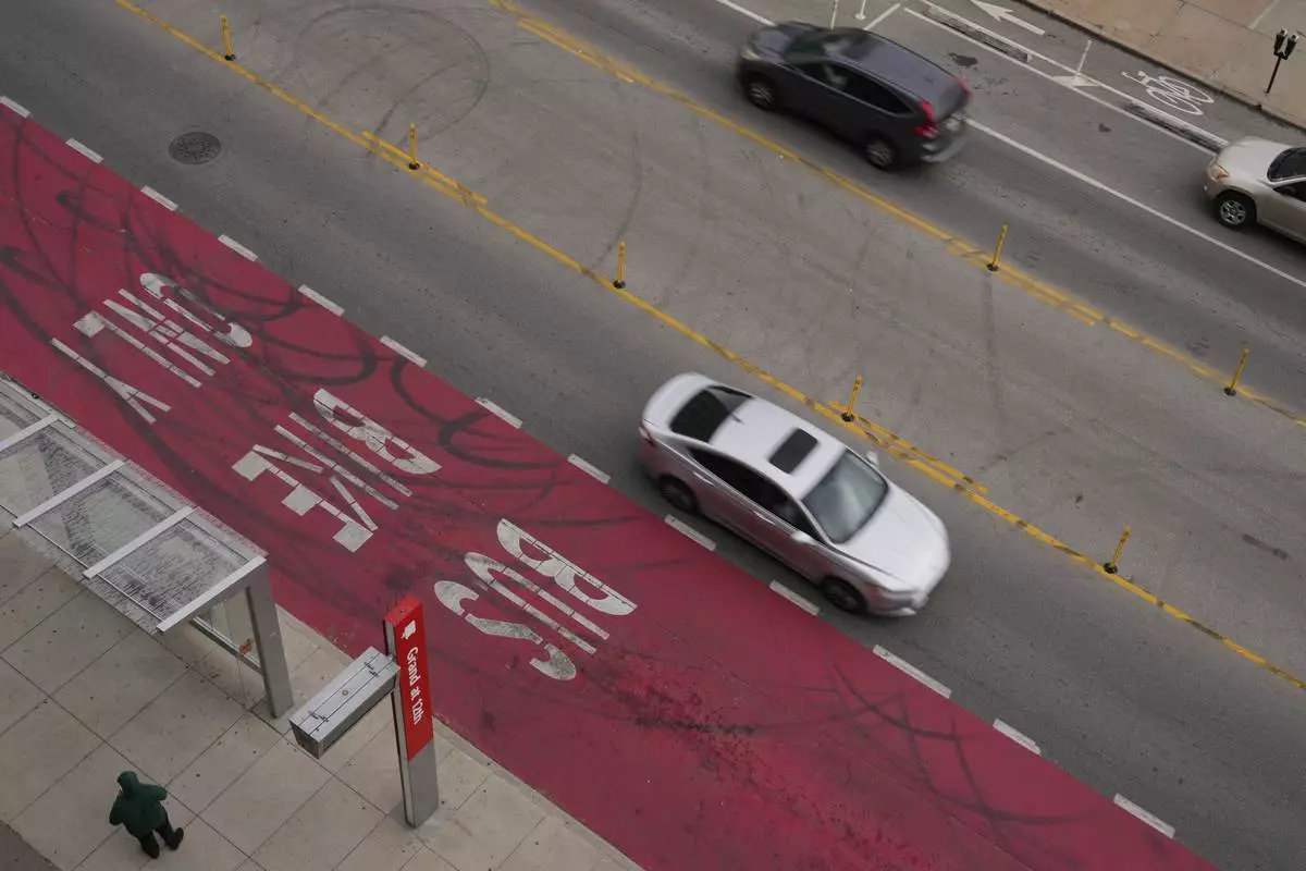 Cars drive on Grand Boulevard in Kansas City, Mo., where the city implemented a "road diet" reducing the street from four lanes to two in an effort to reduce speeding and accidents, Thursday, April 17, 2025. (AP Photo/Charlie Riedel)