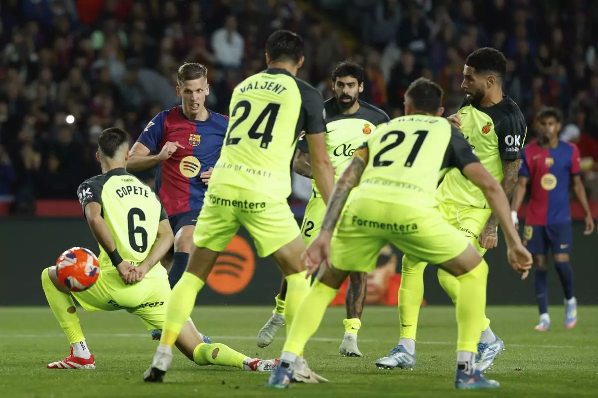Barcelona's Dani Olmo, second left, scores his side's opening goal during a Spanish La Liga soccer match between Barcelona and Mallorca at the Lluis Companys Olympic stadium in Barcelona, Spain, Tuesday, April 22, 2025. (AP Photo/Joan Monfort)