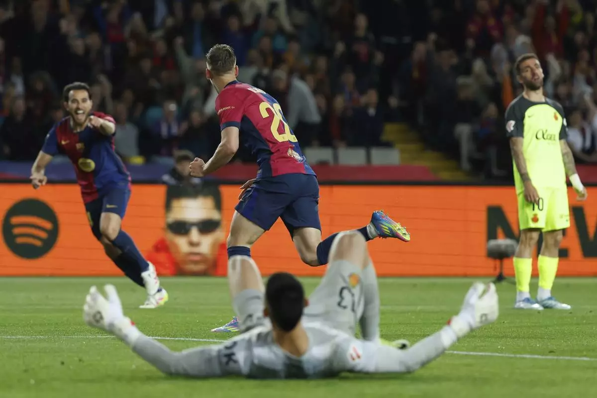 Barcelona's Dani Olmo, center, celebrates with scoring his side's opening goal during a Spanish La Liga soccer match between Barcelona and Mallorca at the Lluis Companys Olympic stadium in Barcelona, Spain, Tuesday, April 22, 2025. (AP Photo/Joan Monfort)