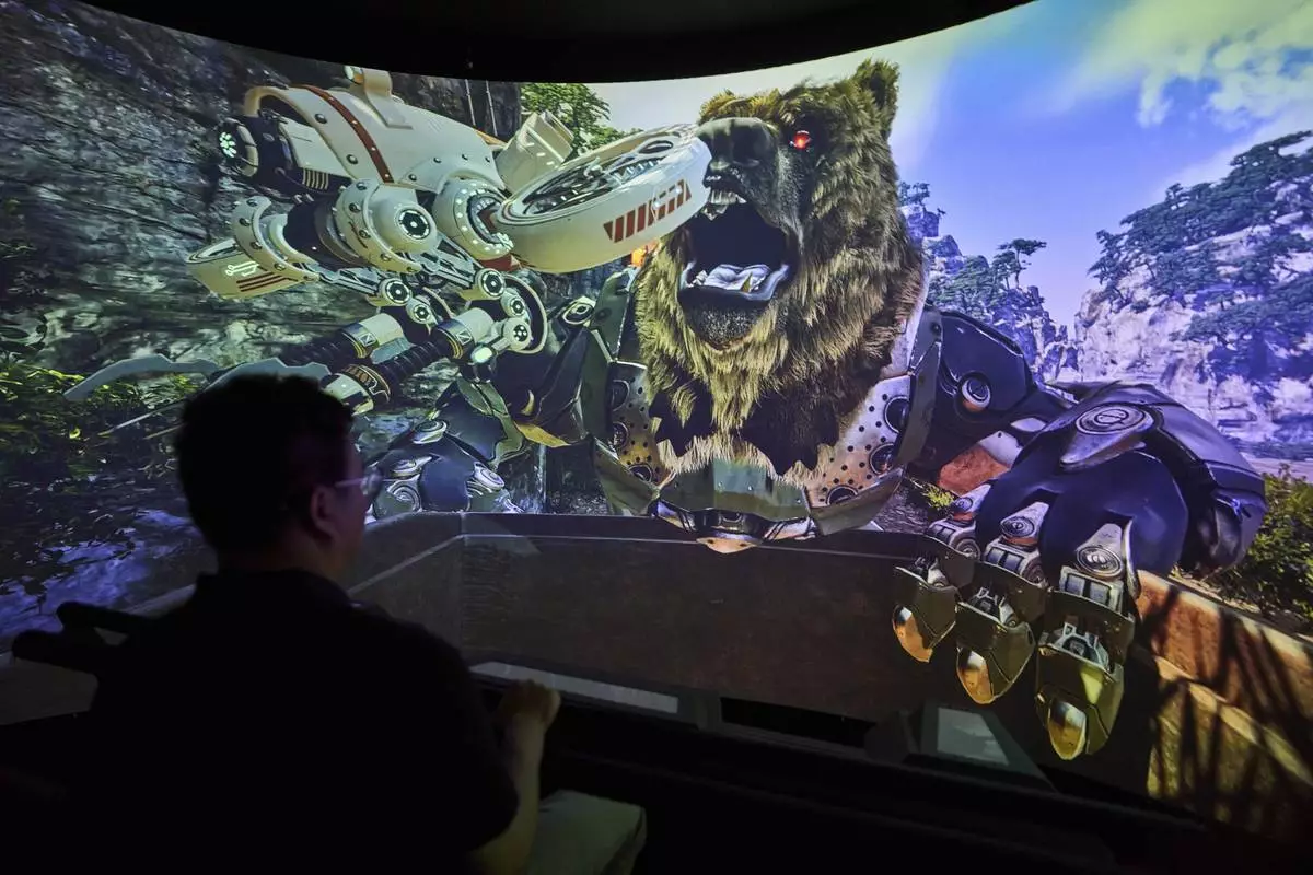 A man experience a 3D ride at the experience center of Zhuoyuan Tech Co., Ltd in Panyu district of Guangzhou city in southern China's Guangdong province on Wednesday, April 16, 2025. (AP Photo/Ng Han Guan)