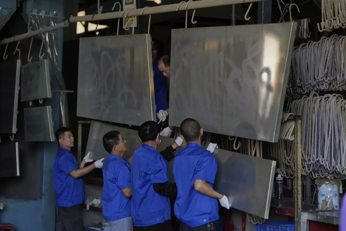 Workers prepare aluminum panels for coating at a factory of Kam Pin Industrial (HK) Ltd, in Dongguan city in southern China's Guangdong province on Thursday, April 17, 2025. (AP Photo/Ng Han Guan)