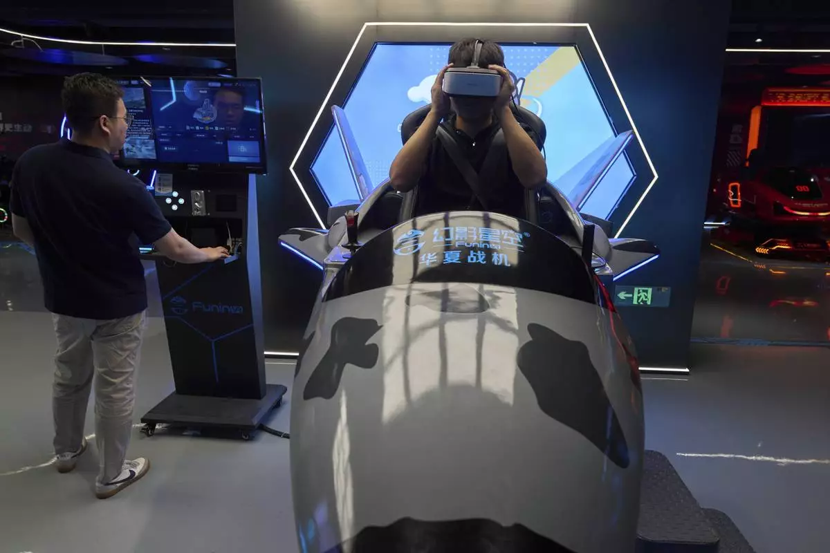 A worker tries out a virtual reality platform at the experience center of Zhuoyuan Tech Co., Ltd in Panyu district of Guangzhou city in southern China's Guangdong province on Wednesday, April 16, 2025. (AP Photo/Ng Han Guan)
