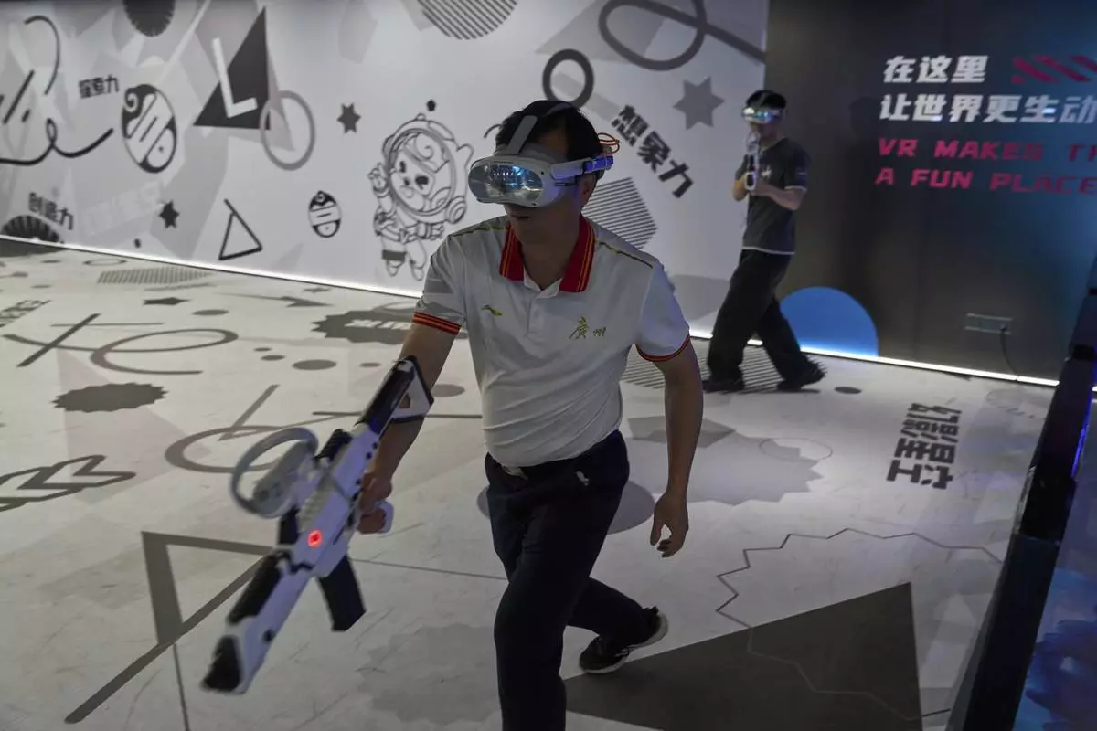 Visitors try out a virtual reality game at the experience center of Zhuoyuan Tech Co., Ltd in Panyu district of Guangzhou city in southern China's Guangdong province on Wednesday, April 16, 2025. (AP Photo/Ng Han Guan)