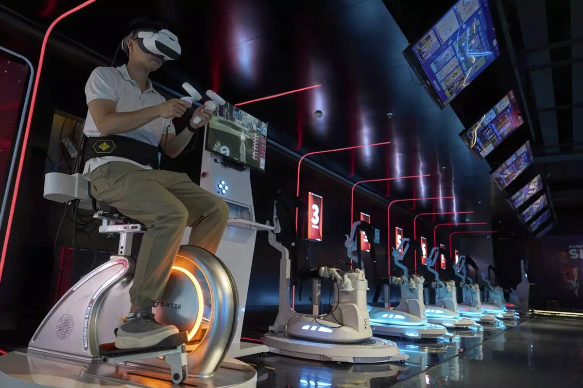 A worker tries out a virtual reality platform at the experience center of Zhuoyuan Tech Co., Ltd in Panyu district of Guangzhou city in southern China's Guangdong province on Wednesday, April 16, 2025. (AP Photo/Ng Han Guan)