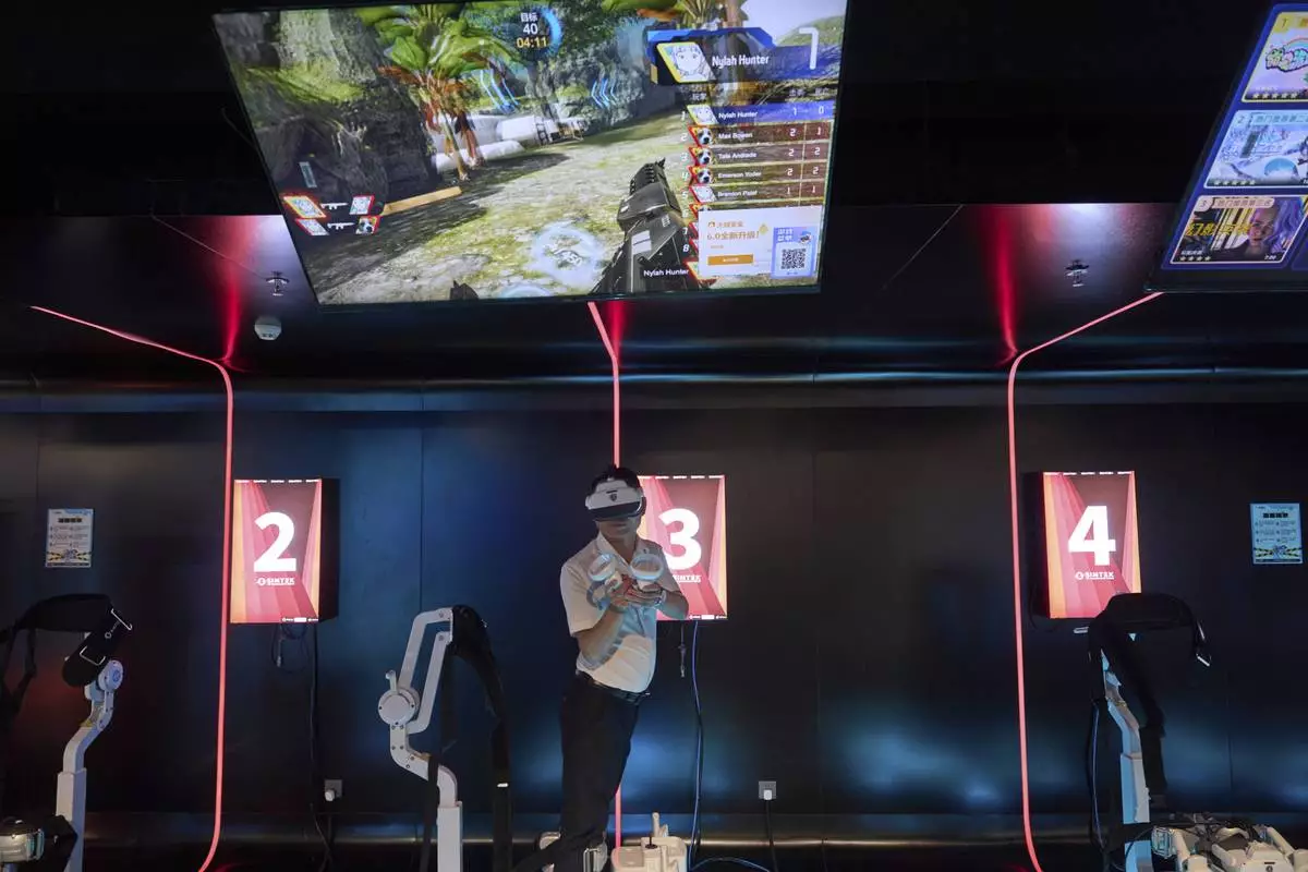 A man tries out a virtual reality game at the experience center of Zhuoyuan Tech Co., Ltd in Panyu district of Guangzhou city in southern China's Guangdong province on Wednesday, April 16, 2025. (AP Photo/Ng Han Guan)