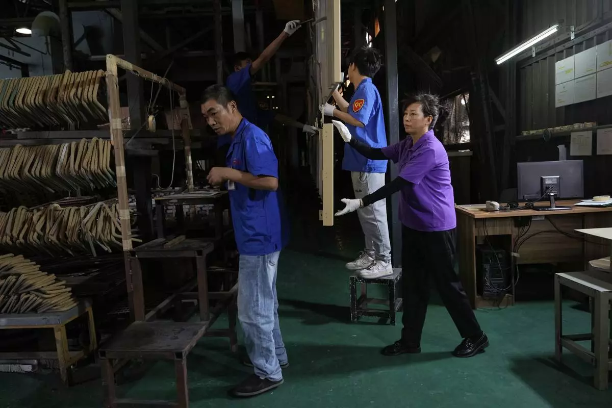 Workers check aluminum panels produced at a factory of Kam Pin Industrial (HK) Ltd, in Dongguan city in southern China's Guangdong province on Thursday, April 17, 2025. (AP Photo/Ng Han Guan)