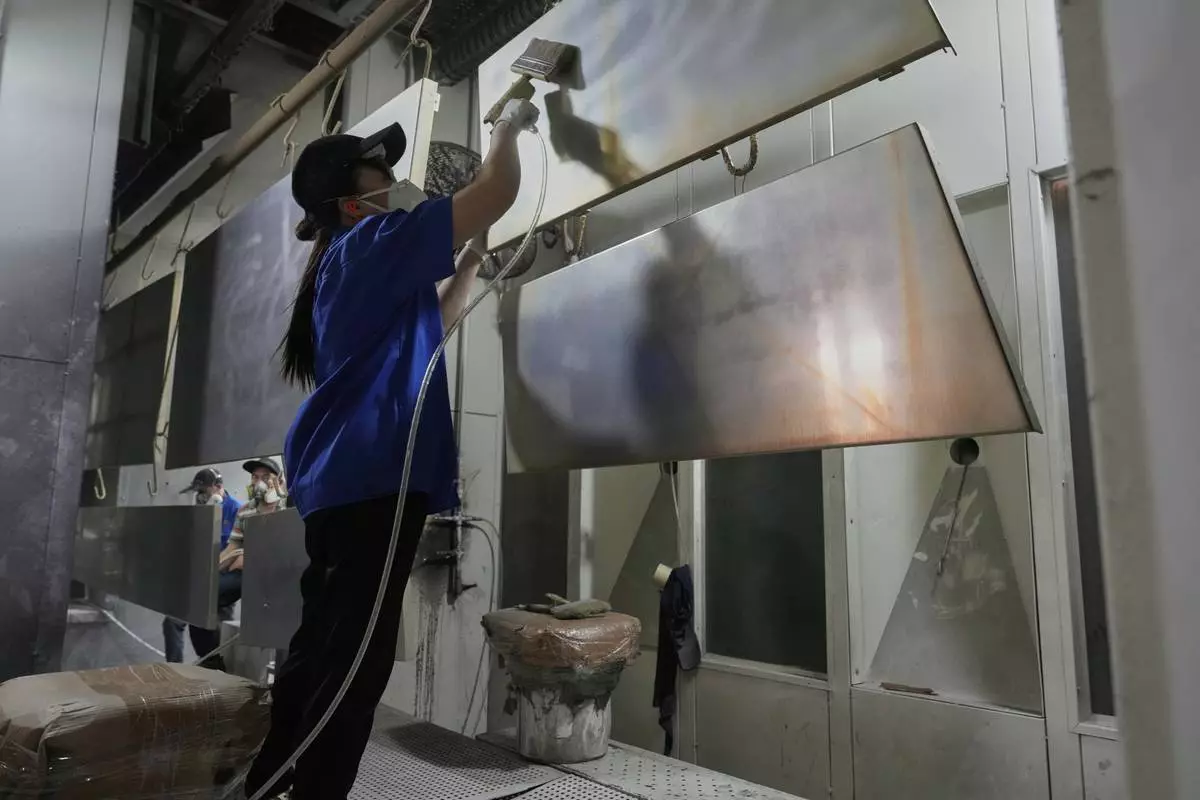 A worker prepares aluminum panels for coating at a factory of Kam Pin Industrial (HK) Ltd, in Dongguan city in southern China's Guangdong province on Thursday, April 17, 2025. (AP Photo/Ng Han Guan)