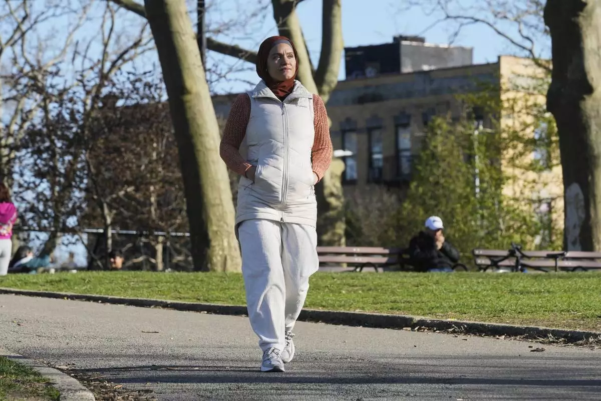 Daniris Espinal walks through Sunset Park, in the Brooklyn borough of New York, Thursday, April 17, 2025. (AP Photo/Richard Drew)