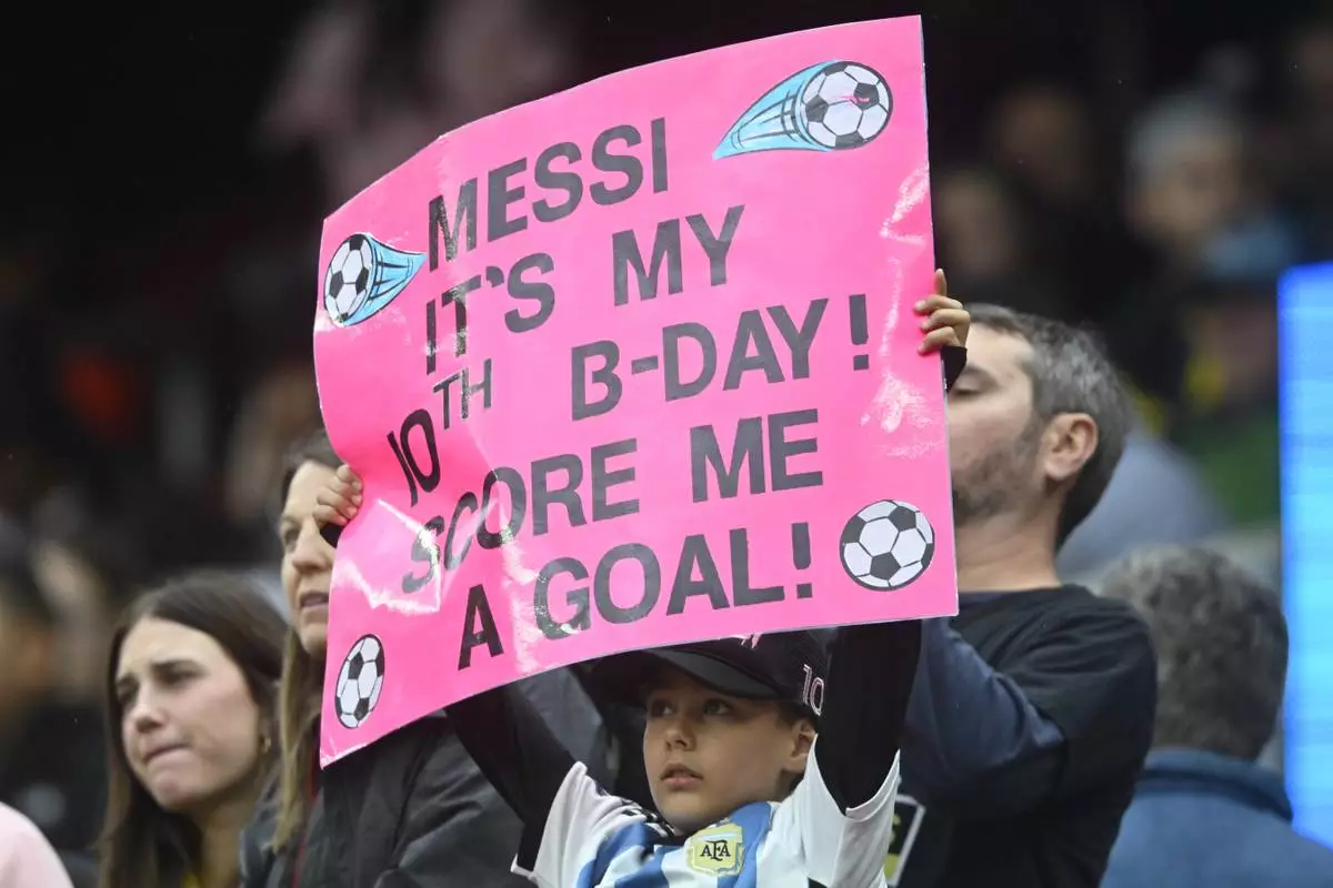 A fan holds a sign during the first half of an MLS soccer match between the Columbus Crew and Inter Miami, Saturday, April 19, 2025, in Cleveland, Ohio. (AP Photo/David Richard)