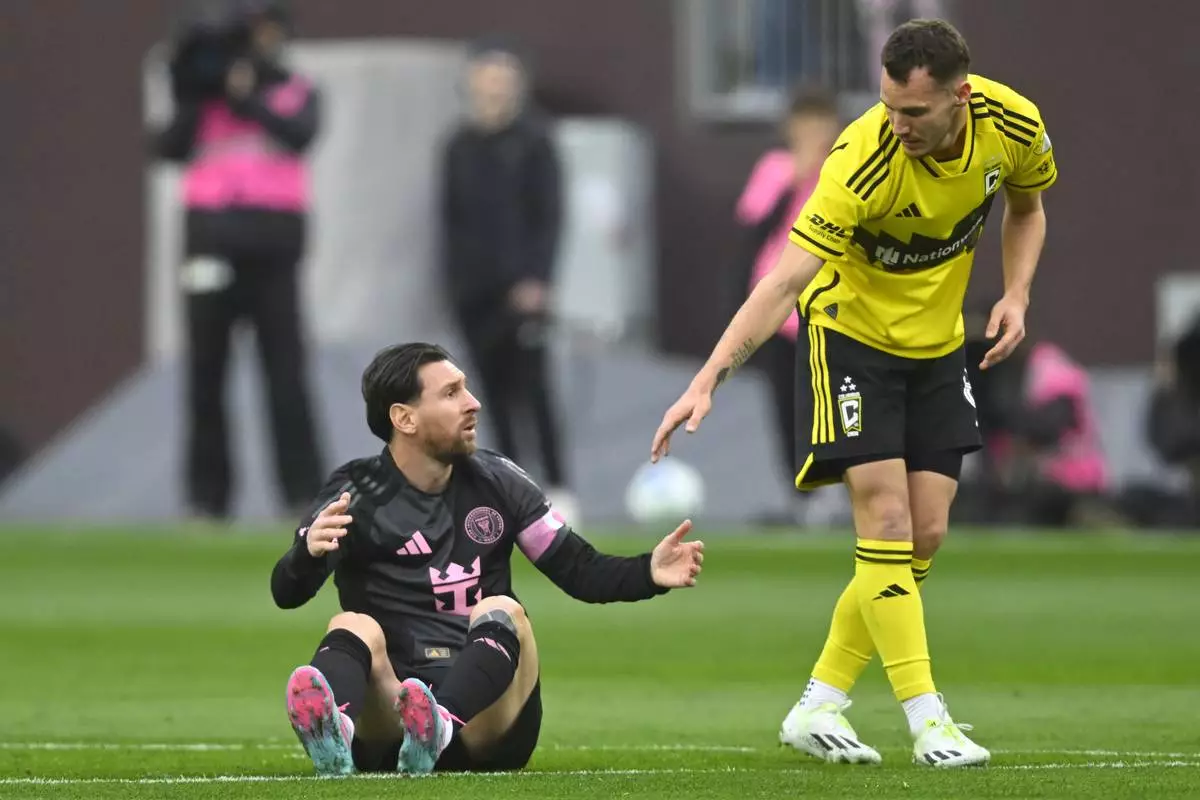 Columbus Crew midfielder Daniel Gazdag, right, reaches out to Inter Miami CF forward Lionel Messi during the first half of an MLS soccer match on Saturday, April 19, 2025, in Cleveland, Ohio. (AP Photo/David Richard)