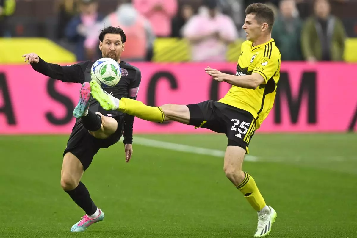 Inter Miami CF forward Lionel Messi, left, and Columbus Crew midfielder Sean Zawadzki kick for the ball during the second half of an MLS soccer match on Saturday, April 19, 2025, in Cleveland, Ohio. (AP Photo/David Richard)