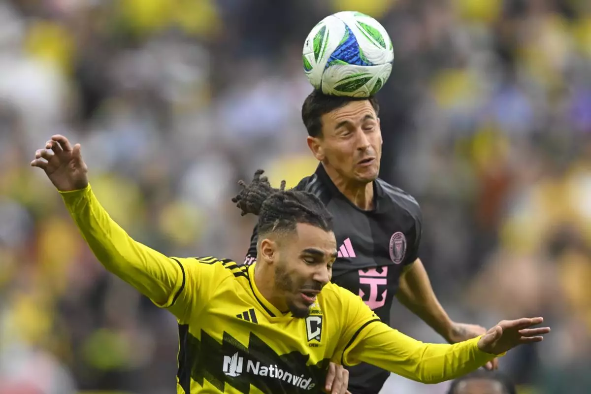 Inter Miami midfielder Tadeo Allende, top, heads the ball over Columbus Crew defender Mohamed Farsi, bottom, during the first half of an MLS soccer match Saturday, April 19, 2025, in Cleveland, Ohio. (AP Photo/David Richard)