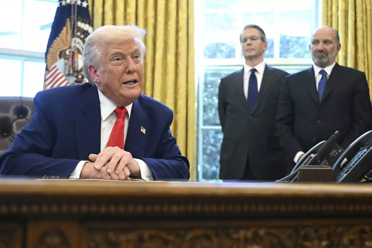 President Donald Trump speaks after signing an executive order in the Oval Office of the White House Wednesday, April 9, 2025, in Washington, as Treasury Secretary Scott Bessent and Commerce Secretary Howard Lutnick listen. (Pool via AP)
