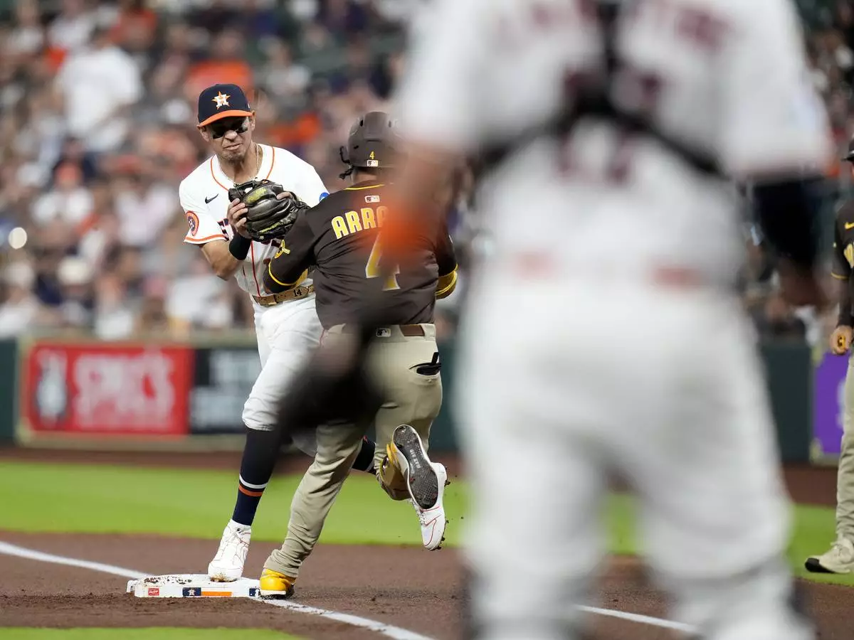 San Diego Padres' Luis Arraez (4) collides with Houston Astros second baseman Mauricio Dubon, left, at first base resulting in Arraez being carted off the field during the first inning of a baseball game Sunday, April 20, 2025, in Houston. (AP Photo/Karen Warren)