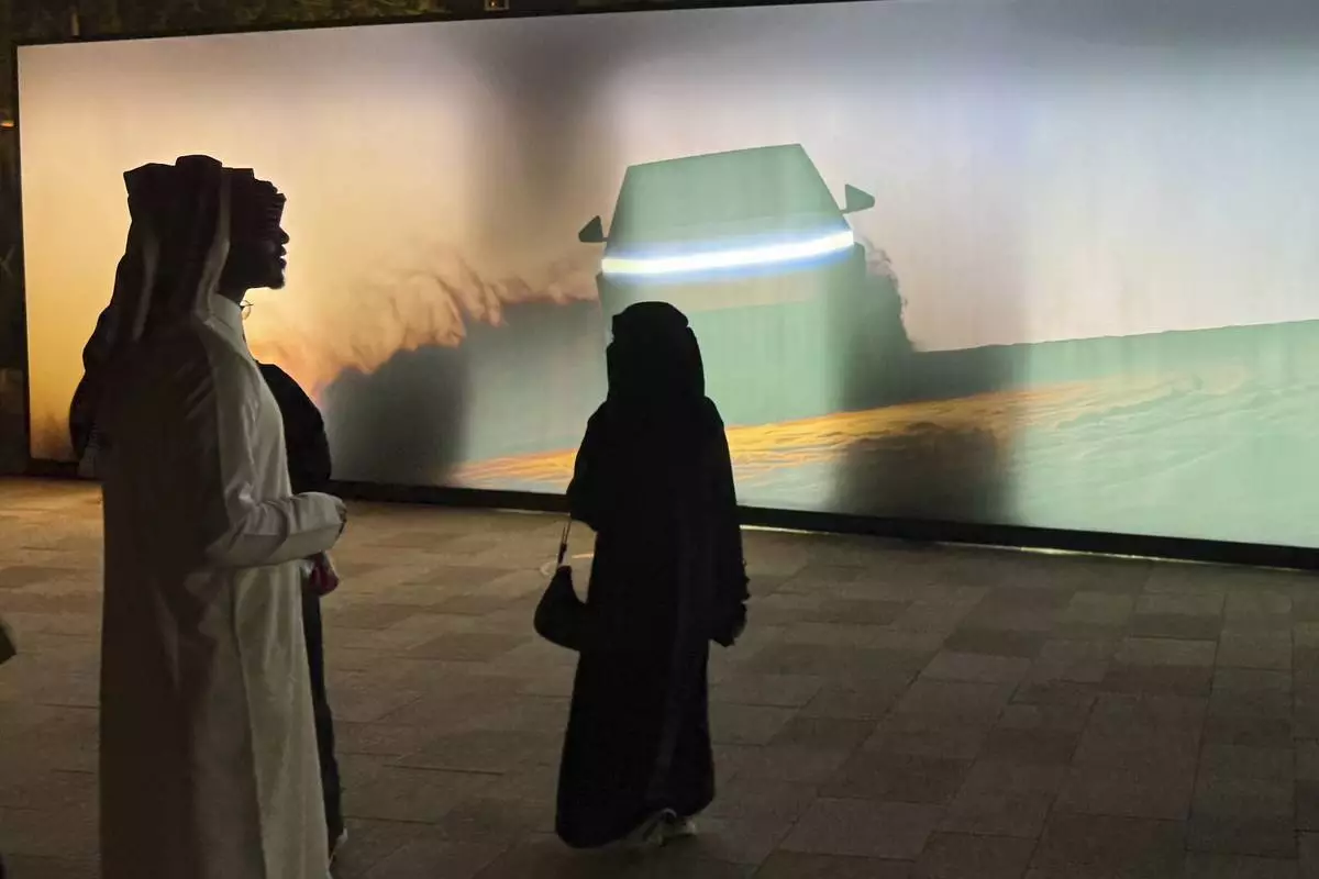 People attend a celebration for the start of Tesla operations in Saudi Arabia in historic Diriyah near Riyadh, Saudi Arabia, on Thursday, April 10, 2025 (AP Photo/Baraa Anwer)
