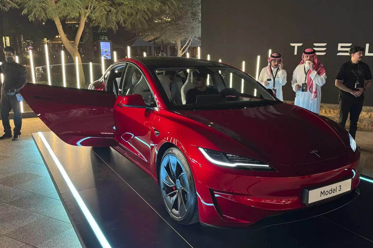 People attend a celebration for the start of Tesla operations in Saudi Arabia in historic Diriyah near Riyadh, Saudi Arabia, on Thursday, April 10, 2025 (AP Photo/Baraa Anwer)