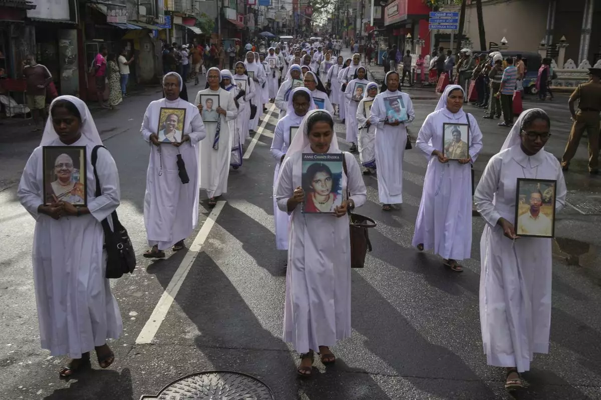 Sri Lankan Catholics nuns carry portraits of the victims of the 2019 Easter Sunday attacks during its sixth anniversary commemoration in Colombo, Sri Lanka, Monday, April 21, 2025. (AP Photo/Eranga Jayawardena)