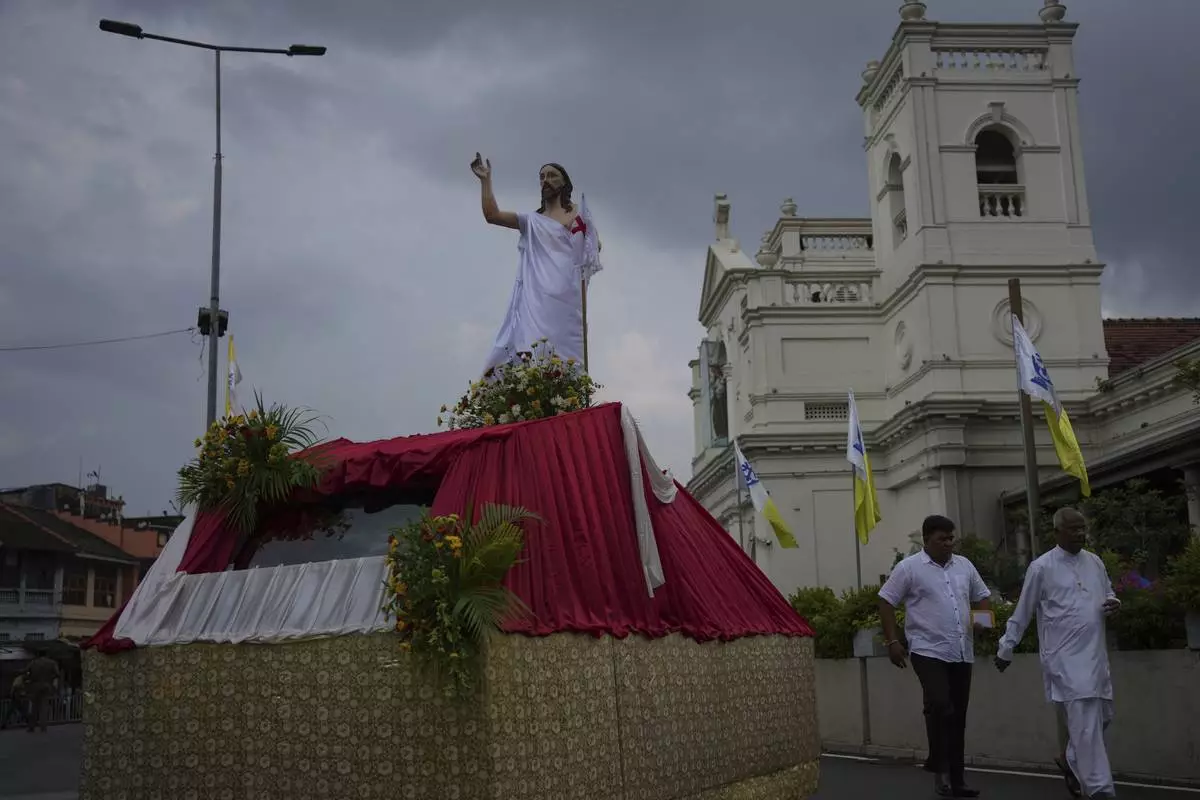 Sri Lankan Catholics walk past a statue of Jesus Christ outside St. Anthony's Church during a ceremony marking the sixth anniversary of the 2019 Easter Sunday attacks in Colombo, Sri Lanka, Monday, April 21, 2025. (AP Photo/Eranga Jayawardena)