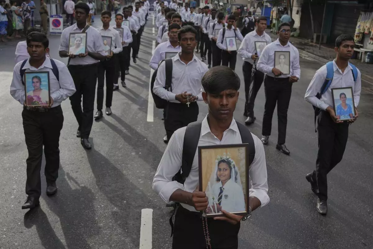 Sri Lankan Catholics carry portraits of the victims of the 2019 Easter Sunday attacks during its sixth anniversary commemoration in Colombo, Sri Lanka, Monday, April 21, 2025. (AP Photo/Eranga Jayawardena)
