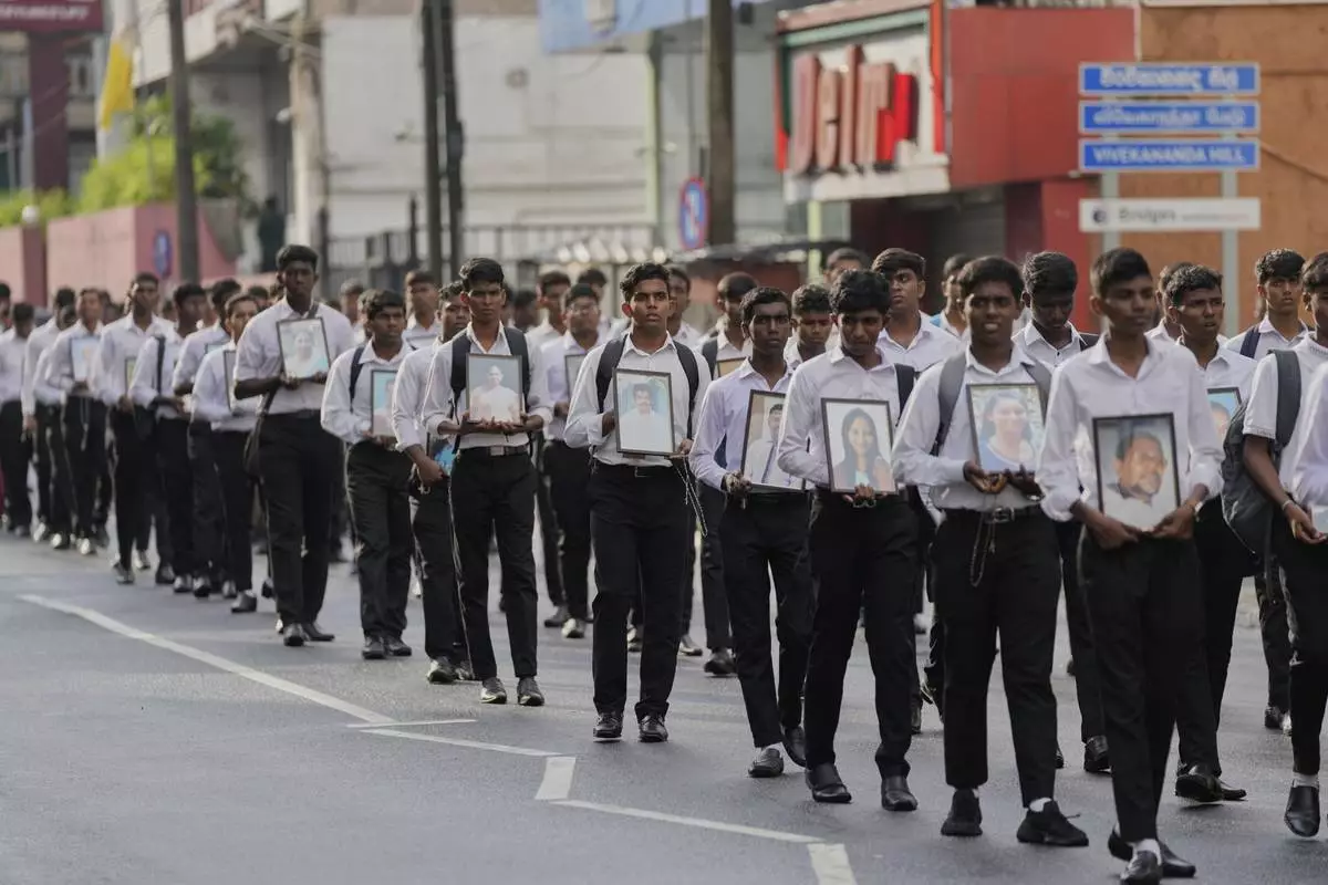 Sri Lankan Catholics walk carrying portraits of the victims of the 2019 Easter Sunday attacks during its sixth anniversary commemoration in Colombo, Sri Lanka, Monday, April 21, 2025. (AP Photo/Eranga Jayawardena)