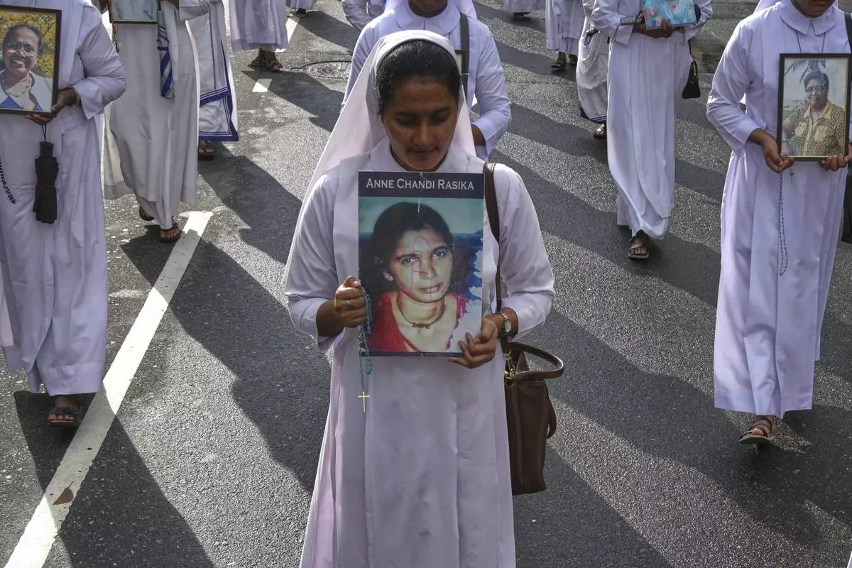 Sri Lankan Catholics nuns carry portraits of the victims of the 2019 Easter Sunday attacks during its sixth anniversary commemoration in Colombo, Sri Lanka, Monday, April 21, 2025. (AP Photo/Eranga Jayawardena)