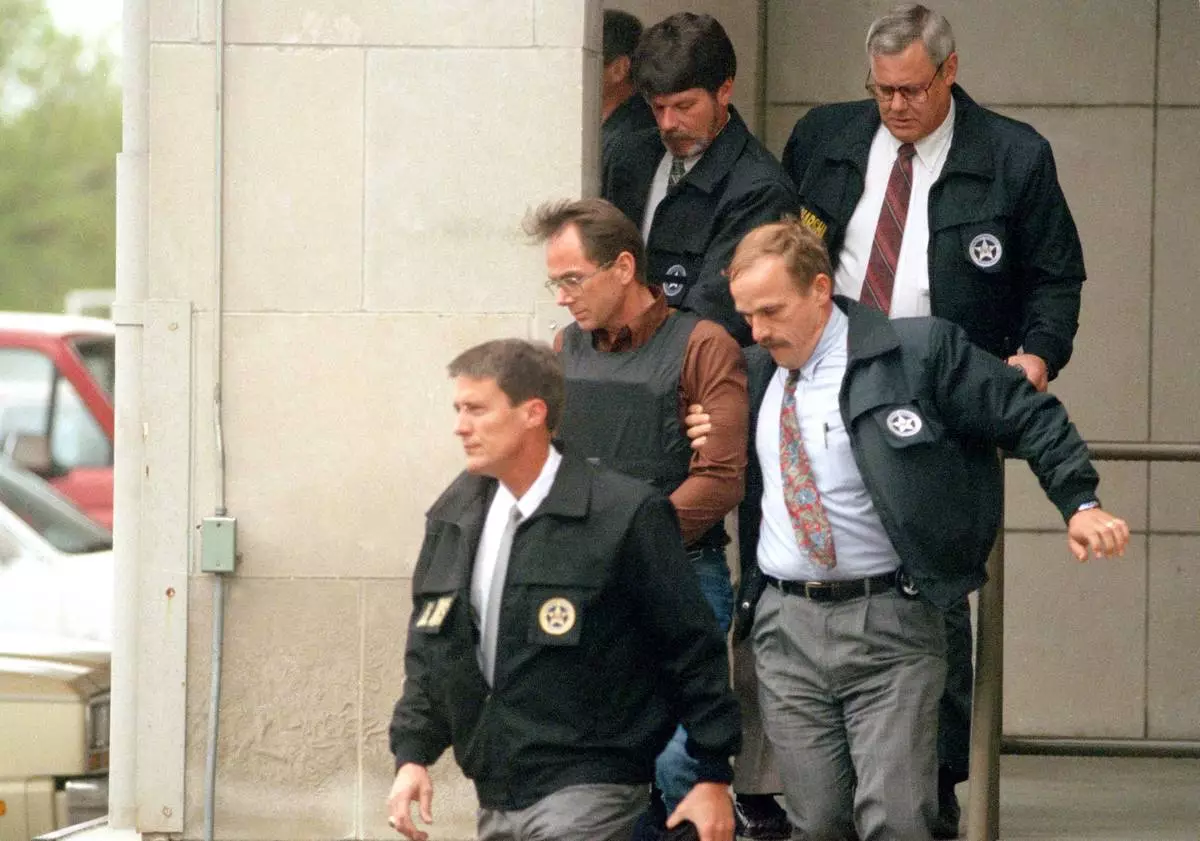 FILE - Terry Nichols, wearing a bullet-proof vest, is escorted by U.S. marshals as he leaves the federal courthouse in Wichita, Kansas, on April 26, 1995. (AP Photo/Steve Rasmussen, File)
