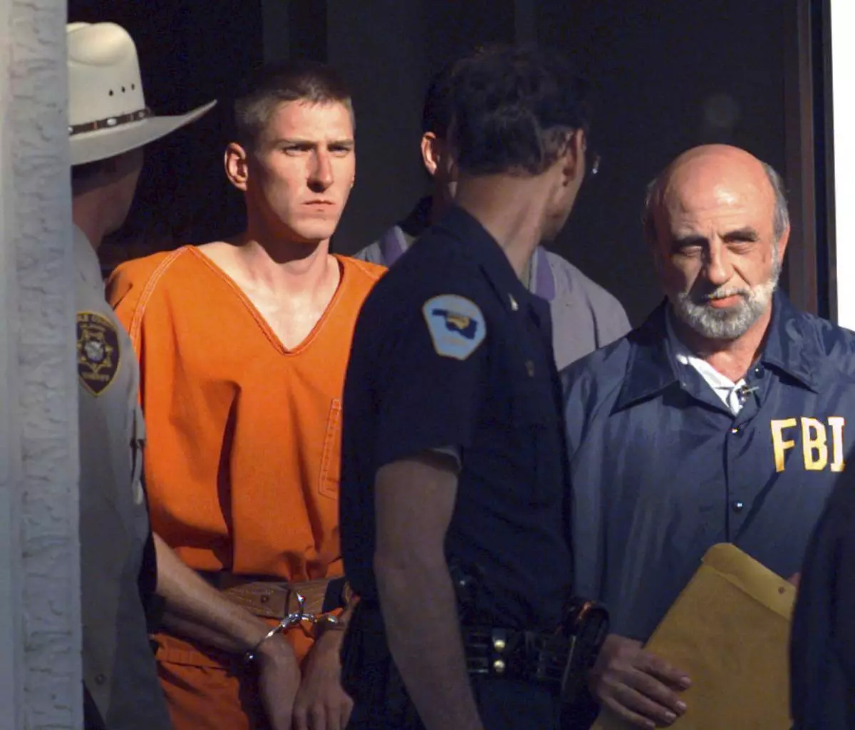 FILE - Timothy James McVeigh, identified as a suspect in the bombing of the Oklahoma City Federal building, is lead out of the Noble County Courthouse in Perry, Okla., by state and federal law enforcement officials on April 21, 1995. (AP Photo/John Gaps III, File)
