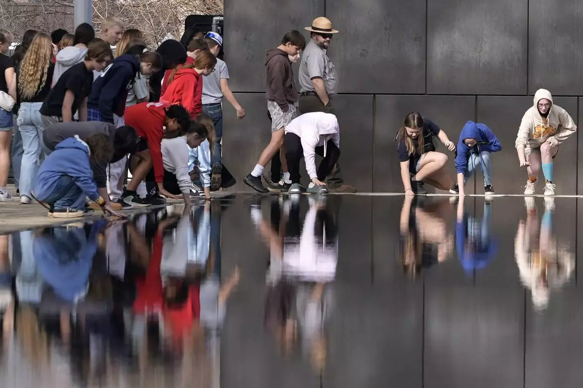 Visitors touch the Reacting Pond at the Oklahoma City National Memorial & Museum in Oklahoma City on March 12, 2025. (AP Photo/LM Otero)