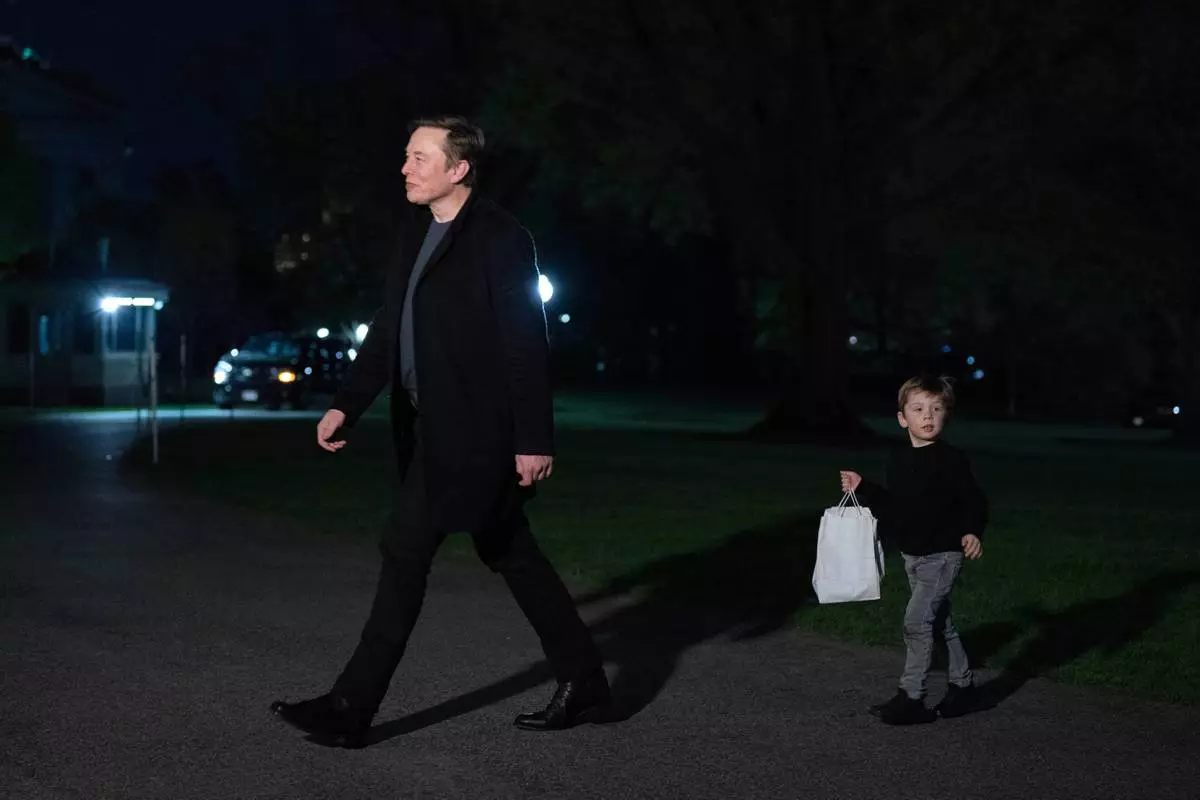 Elon Musk and his son X Æ A-Xii walk on the South Lawn upon their arrival to the White House in Washington, Sunday, April 13, 2025. (AP Photo/Jose Luis Magana)
