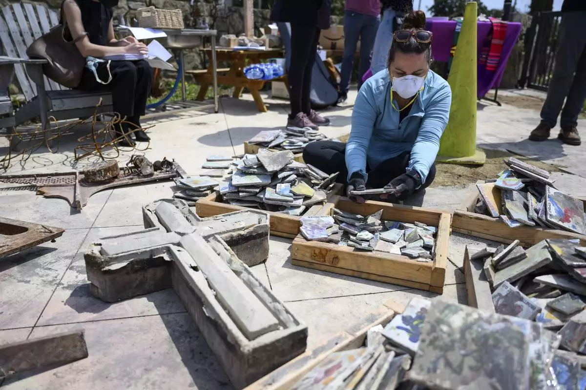 Joey Hargrove sorts through debris during a Cross Walk event by the Community United Methodist Church of the Pacific Palisades, Friday, April 18, 2025, in the Pacific Palisades area of Los Angeles. (AP Photo/William Liang)