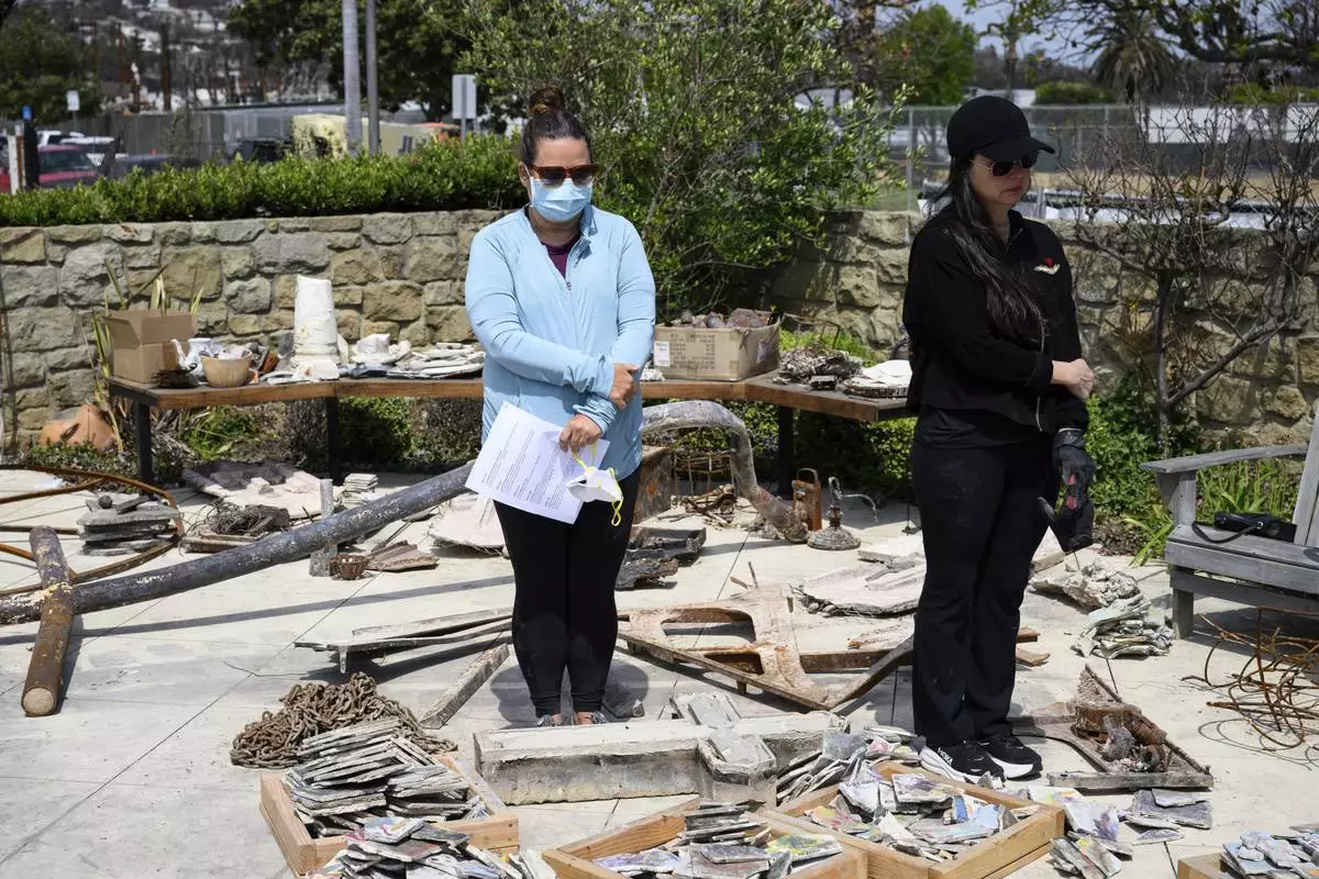 Members of a church listen to a prayer during a Cross Walk event by the Community United Methodist Church of the Pacific Palisades, Friday, April 18, 2025, in the Pacific Palisades area of Los Angeles. (AP Photo/William Liang)