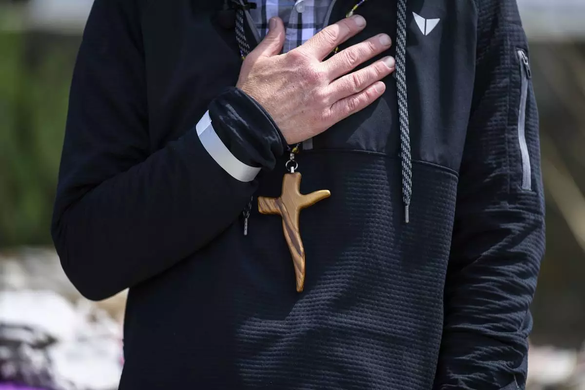 A cross necklace is seen on Pastor John Shaver during a Cross Walk event by the Community United Methodist Church of the Pacific Palisades, Friday, April 18, 2025, in the Pacific Palisades area of Los Angeles. (AP Photo/William Liang)