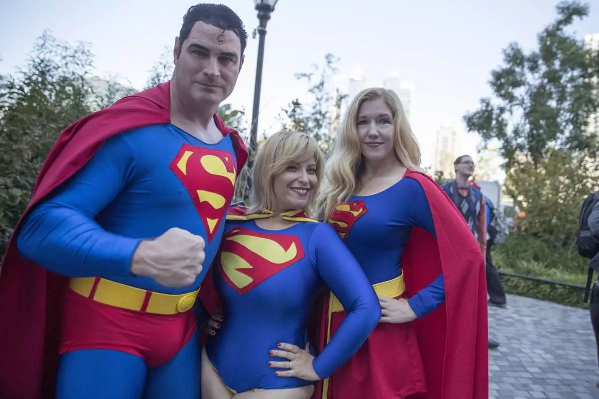 FILE - Superman fans Michael Byrnes, left, Frances Tirado, center, and Amy Byrnes pose for a photo on their way to Comic Con, Friday, Oct. 7, 2016, in New York. (AP Photo/Mary Altaffer, file)