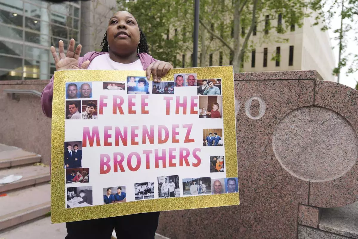 A supporter holds a sign outside of court before a hearing in the case of Erik and Lyle Menendez Thursday, April 17, 2025, in Los Angeles. (AP Photo/Damian Dovarganes)