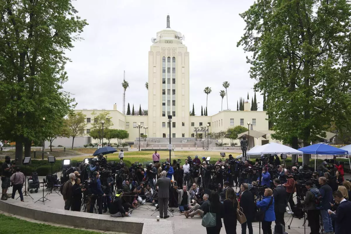 Attorney Mark Geragos, representing Erik and Lyle Menendez, bottom center, speaks to the media as he arrives for a hearing in their case, Thursday, April 17, 2025, in Los Angeles. (AP Photo/Damian Dovarganes)