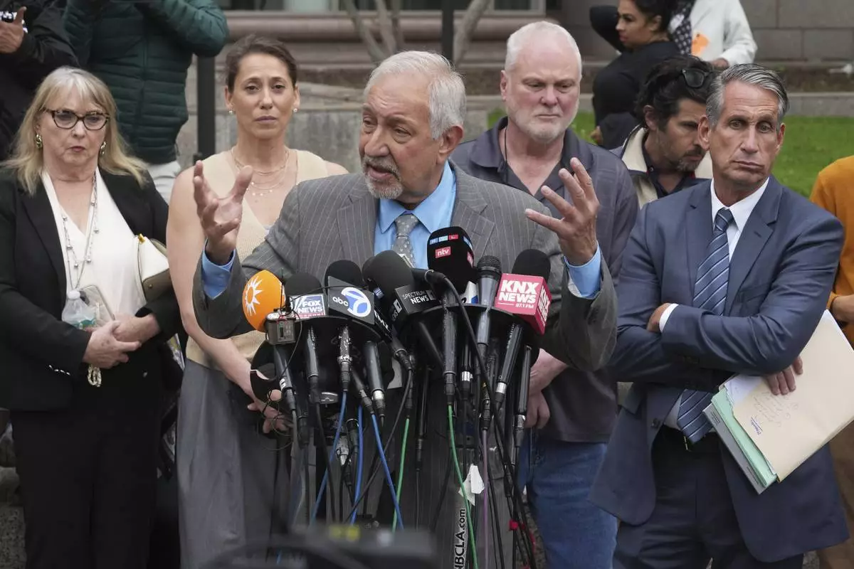 Attorney Mark Geragos, center, representing Erik and Lyle Menendez, who were sentenced in 1996 to life in prison without the possibility of parole for fatally shooting their parents, speaks to the media outside of court after a resentencing hearing in their case, Thursday, April 17, 2025, in Los Angeles. (AP Photo/Damian Dovarganes)